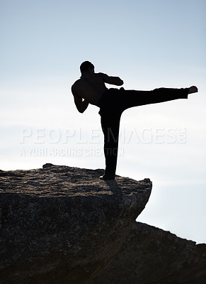 Buy stock photo Karate, kick and fitness man on mountain top for body, power or defense training on blue sky background. Martial arts, MMA and male taekwondo master in nature for exercise, sports or morning cardio