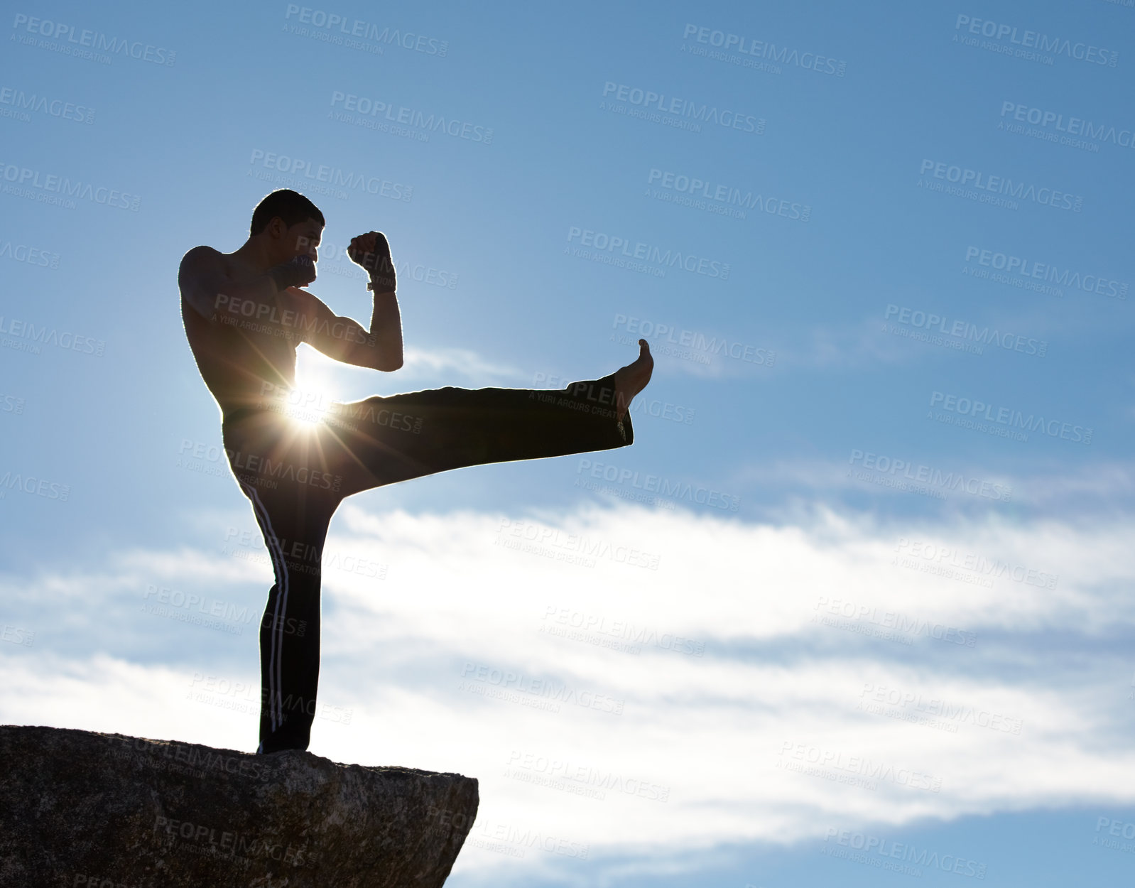 Buy stock photo Karate, fitness man kick on mountain top for body, power or defense training on blue sky background. Martial arts, MMA and male taekwondo master in nature for exercise, sports or morning cardio