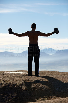 Buy stock photo Weightlifting, fitness and back of man with dumbbells on mountain top for morning cardio on sky background. Weights, energy and rear view of male bodybuilder in nature for training, power or workout