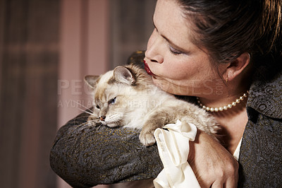 Buy stock photo A woman hugging and giving her cat a big kiss