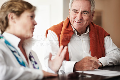 Buy stock photo A senior man and his wife filling out forms at a hotel reception desk