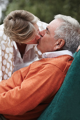 Buy stock photo Kiss, love and senior couple relax in a backyard with freedom, fun and bonding at home together. Gratitude, care and old people with passion, security or support in a yard sharing a romantic moment