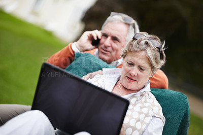 Buy stock photo Phone call, laptop and travel with an old couple in a hotel garden for vacation at a luxury resort. Love, technology or communication with a senior man and woman tourist outdoor on grass at a lodge