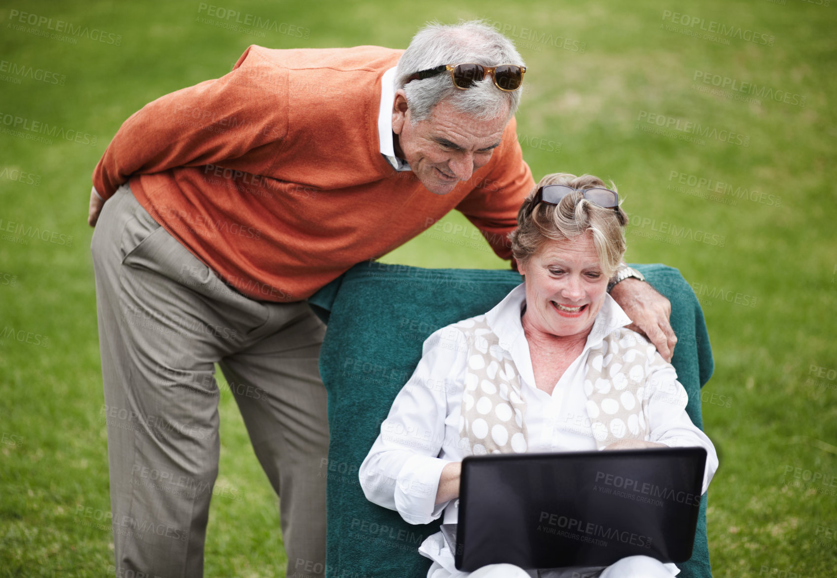 Buy stock photo Love, laptop and an old couple in the garden of a hotel for travel or vacation at a luxury resort. Retirement, technology or social media with a senior man and woman tourist on the grass at a lodge