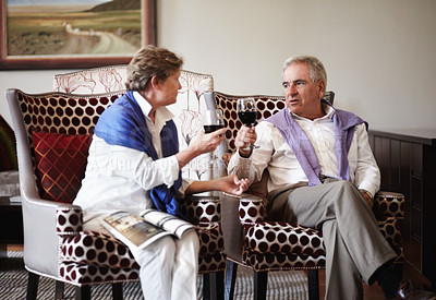 Buy stock photo Toast, love and an old couple drinking wine in their hotel room while on holiday or vacation together. Retirement, sofa or relax with a senior man and woman bonding at a luxury resort for romance