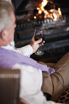 Buy stock photo Relax, senior man with wine at fireplace in hotel lounge or cozy room on retirement vacation. Luxury hospitality, elderly person with glass or drink at holiday accommodation with peace, calm and fire