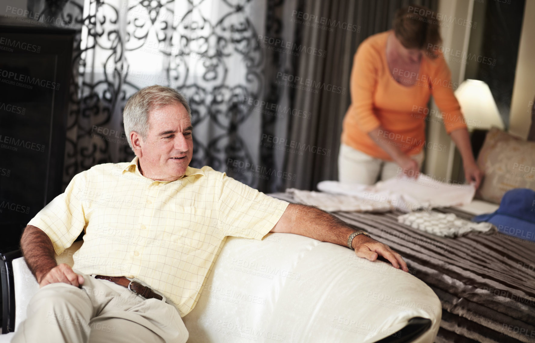 Buy stock photo Hotel, senior man and woman packing clothes in bedroom on retirement holiday chat together. Travel, vacation and happy old couple unpacking with bed, sofa and relax with luxury hospitality in room.