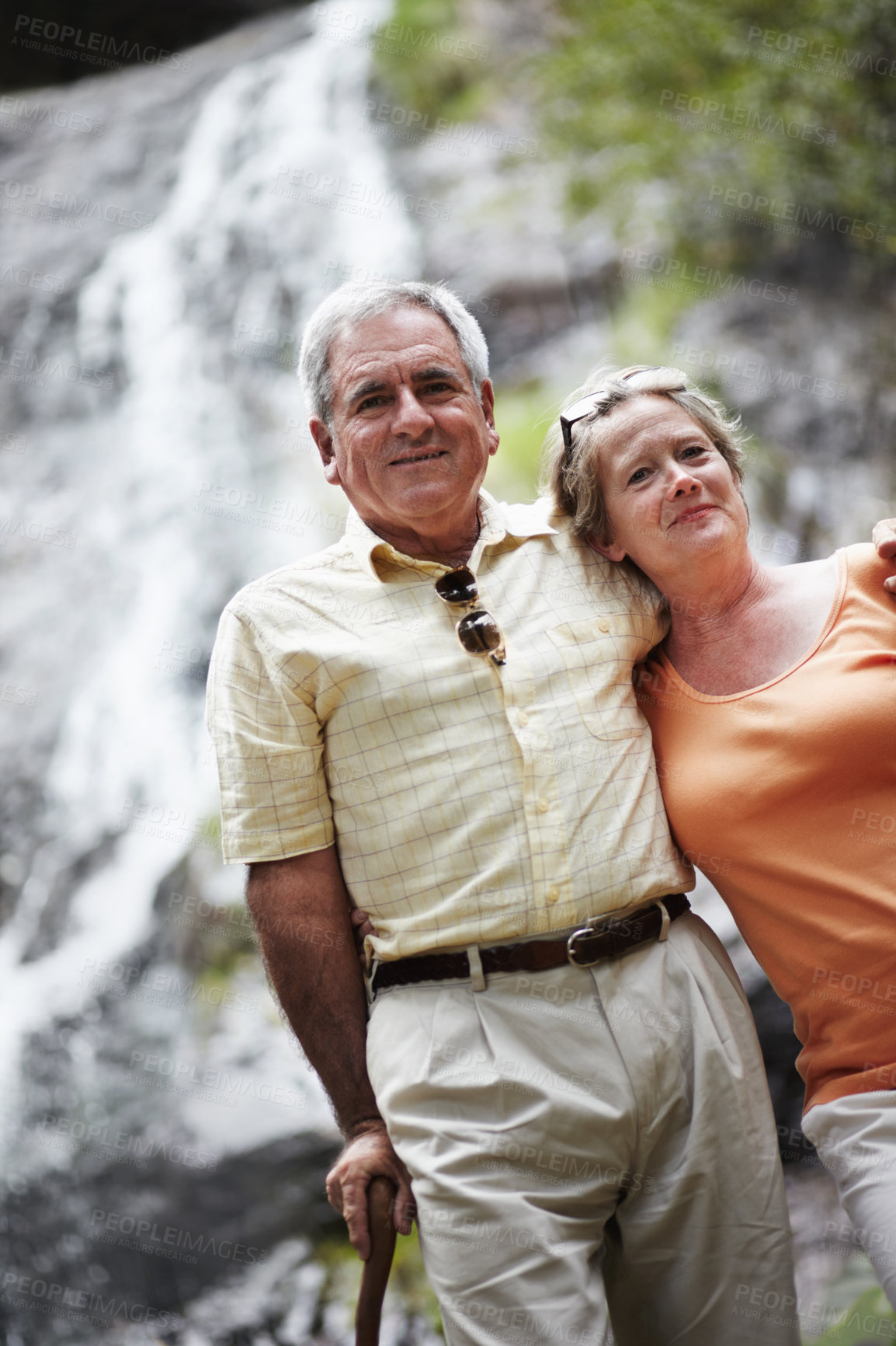 Buy stock photo Senior, man and woman with portrait by waterfall for travel, sightseeing or holiday with happiness. Elderly, couple and face with smile for cascade, vacation and adventure on retirement or tourism
