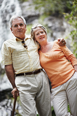 Buy stock photo Elderly, man and woman with portrait by mountain for travel, sightseeing or holiday with happiness. Senior, couple and face with smile for cascade, vacation and adventure on retirement or tourism