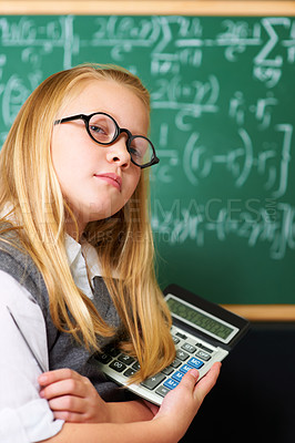 Buy stock photo Child, portrait and calculator by chalkboard for education, learning and problem solving or solution with confidence. Smart kid, student or girl with glasses for school, numbers and math in classroom