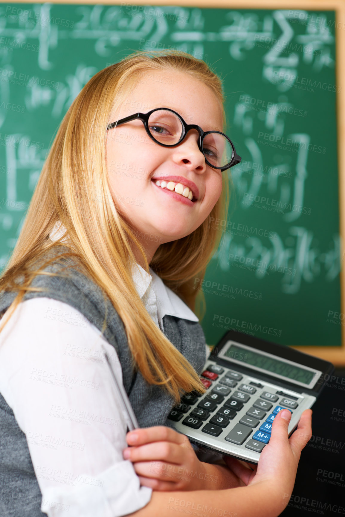 Buy stock photo Smile, calculator and child student in classroom for mathematics homework, lesson or test. Learning, education and portrait of happy young girl kid with glasses and maths equipment by board in school