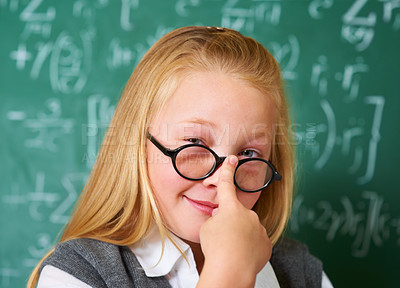Buy stock photo Portrait of nerd, glasses and happy kid by chalkboard in class for learning knowledge, education and study math. Face, student and smile of geek at school, girl or cute child in classroom in Canada