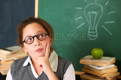 Buy stock photo Child, thinking and lightbulb on chalkboard for education, learning and knowledge with ideas or solution in classroom. Girl, student or school kid for vision, drawing inspiration on board or remember
