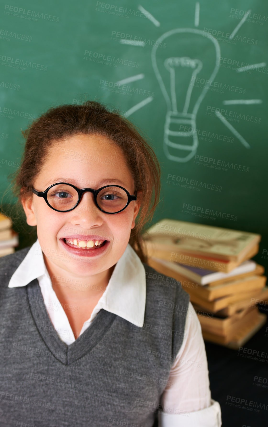 Buy stock photo Thinking, smile and student with light bulb on board for planning, decision or brainstorming in classroom. Education, learning and happy girl child with drawing for choice, vision or future in school