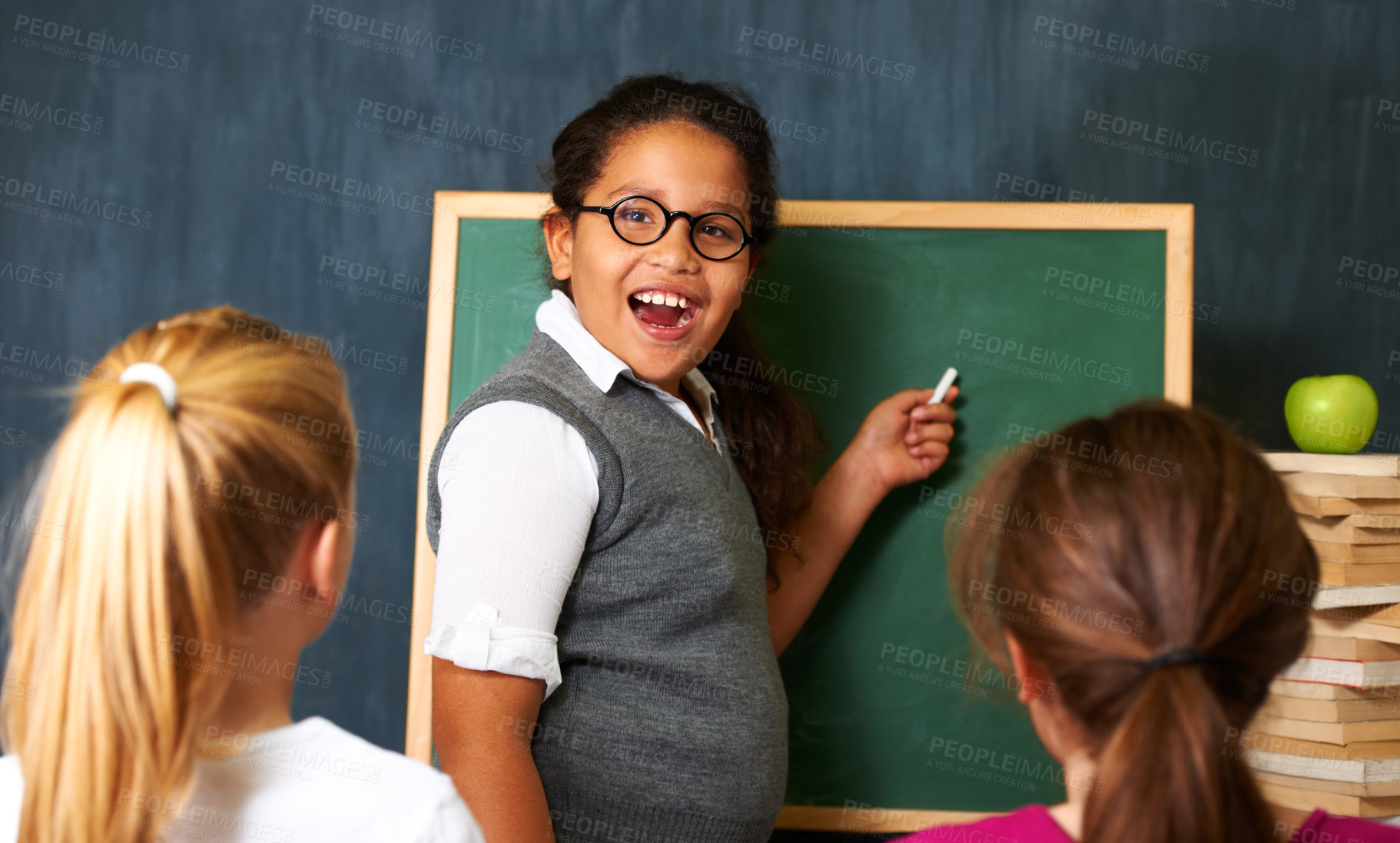 Buy stock photo Excited, board and portrait of child student in a classroom teaching a lesson to friends. Happy, smile and girl kid writing with chalk for education studying, learn or knowledge at school or academy.