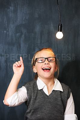 Buy stock photo A cute blonde girl getting an idea below a lightbulb in class