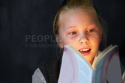 Buy stock photo Smile, reading and child student with book in classroom for knowledge, learning or education. Happy, excited and young girl kid enjoy a story, fantasy or novel at school or academy in the dark.
