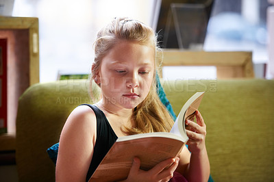 Buy stock photo Relax, reading and child student with a book in living room for education, learning or knowledge. Study, nerd and girl kid enjoying a story, fantasy or novel in the lounge at modern home or house.