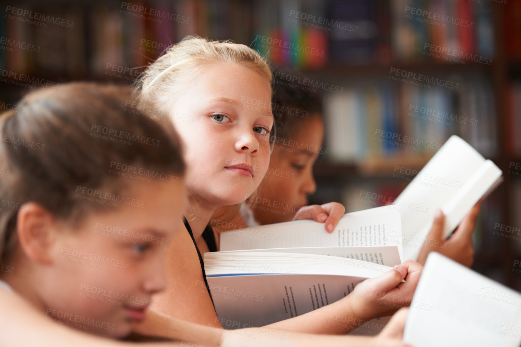 Buy stock photo Girl, portrait and reading books in classroom for education, learning and English language, literature or school resources. Face of kid, students or children with novel, textbook or library textbook