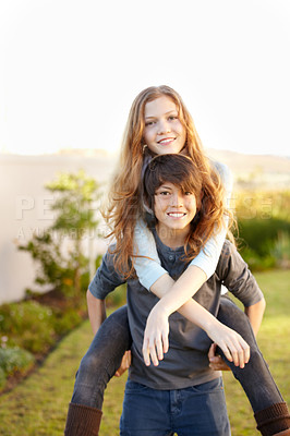 Buy stock photo Portrait of a young boy giving his sister a piggyback in the garden