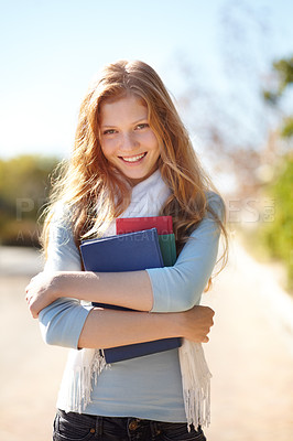 Buy stock photo Portrait of a young girl holding her school books close to her chest