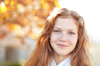 Buy stock photo Portrait of a pretty young girl standing outside under the autumn trees