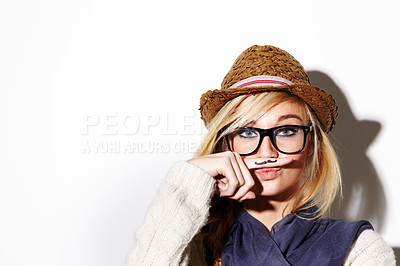 Buy stock photo Closeup of a young woman holding her finger under her nose with a moustache drawn on it