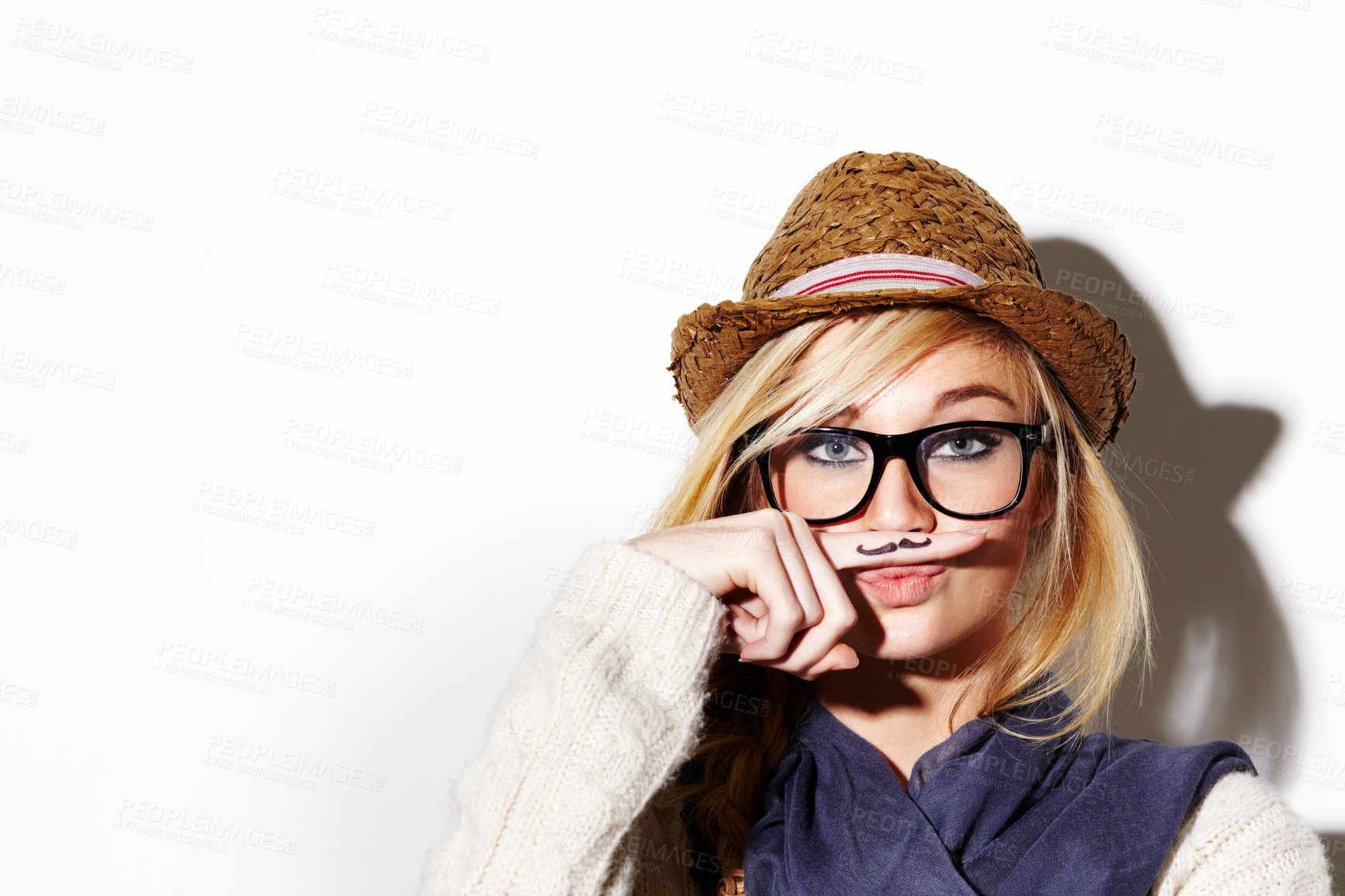 Buy stock photo Closeup of a young woman holding her finger under her nose with a moustache drawn on it