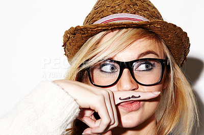 Buy stock photo Girl, isolated and hipster pose with mustache on finger, nerd glasses or funny face in studio white background. Young woman, modern fashion and moustache joke or goofy, weird and photobooth 