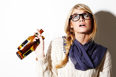 Buy stock photo Closeup of a gorgeous young woman holding two beers in one hand and looking up