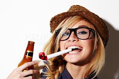 Buy stock photo A gorgeous young woman with a party favor in her mouth holding a beer