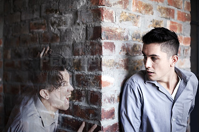 Buy stock photo Man, fear and hide by brick wall with schizophrenia, mental health and panic for ghost or haunted soul. Person, scared or anxiety for character, illusion or paranoid expression and psychological risk