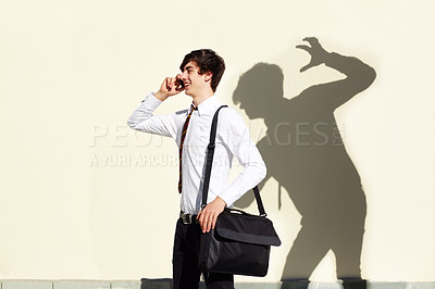 Buy stock photo Shot of a young man being stalked by a ominous shadow of himself