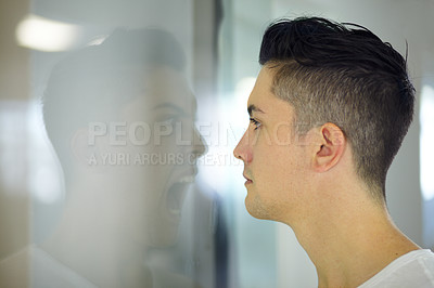 Buy stock photo Young man looking at a screaming reflection of himself