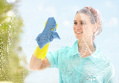 Buy stock photo A happy woman cleaning a window on a bright sunny day, enjoying fresh air with copyspace. Smiling domestic cleaner doing chores, spring cleaning, wiping glass and clearing dirt with a soapy rag