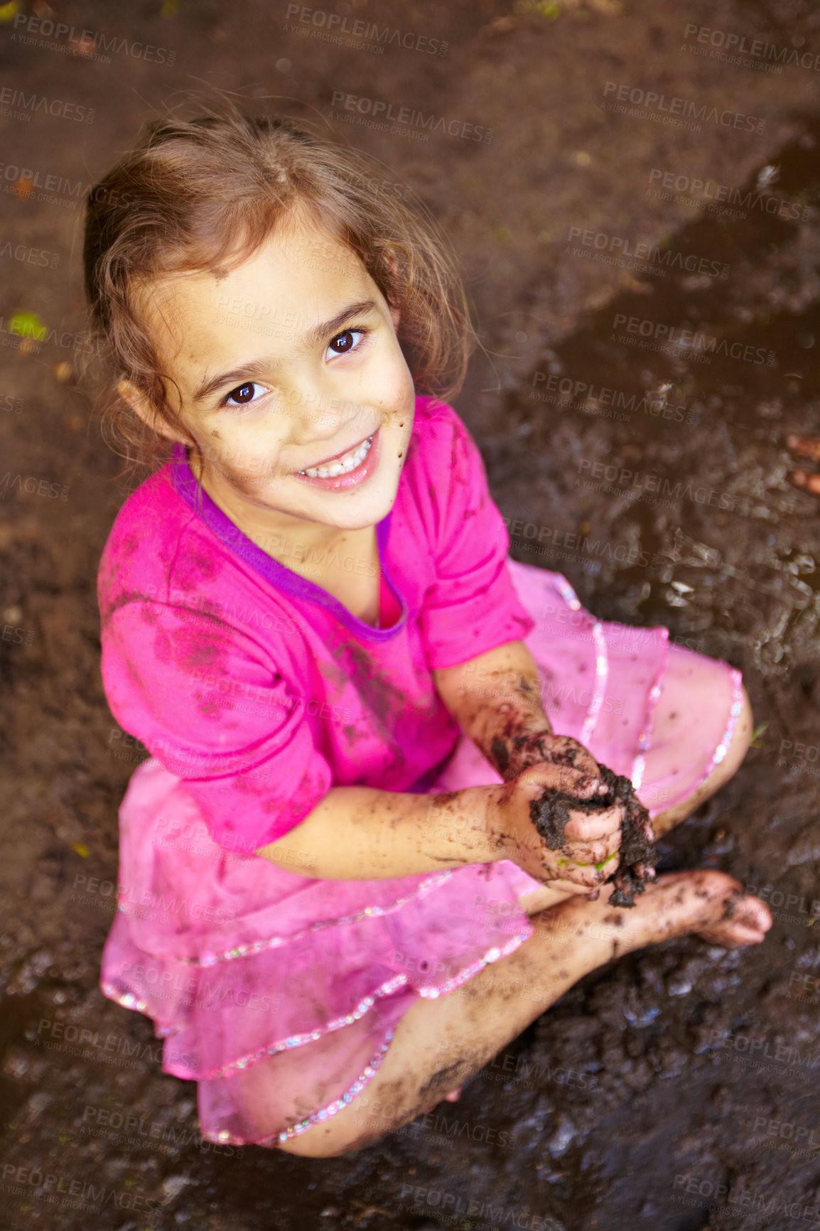 Buy stock photo Girl, child and portrait with smile in mud for freedom, playing and muddy fun in sunshine weather or outdoor. Kid, female and face of person with happiness for activity, enjoyment and relax in dirt