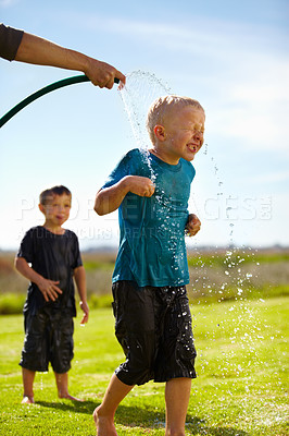 Buy stock photo Kids, boys and hose pipe with water fun, splash and playing outdoor in backyard or garden for sunshine. Children, brother and people on grass or lawn with happiness, activity and enjoyment in summer