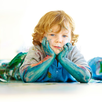 Buy stock photo Messy, portrait and a child in paint after art in class, school or education on the floor. Happy, relax and a boy, kid or kindergarten student covered in color after painting, creativity or playing