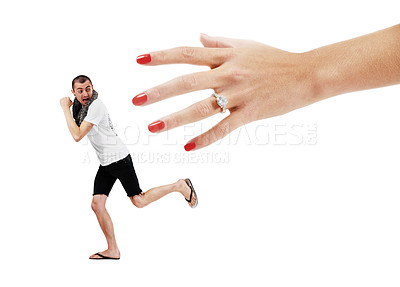 Buy stock photo A young man trying to run away from a giant hand wearing a wedding ring