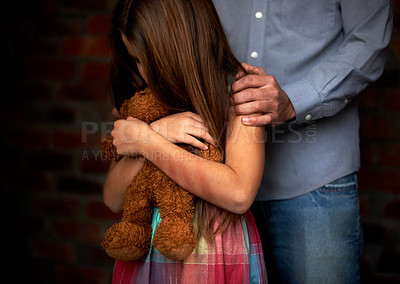 Buy stock photo Abused little girl with her abuser gripping her shoulder