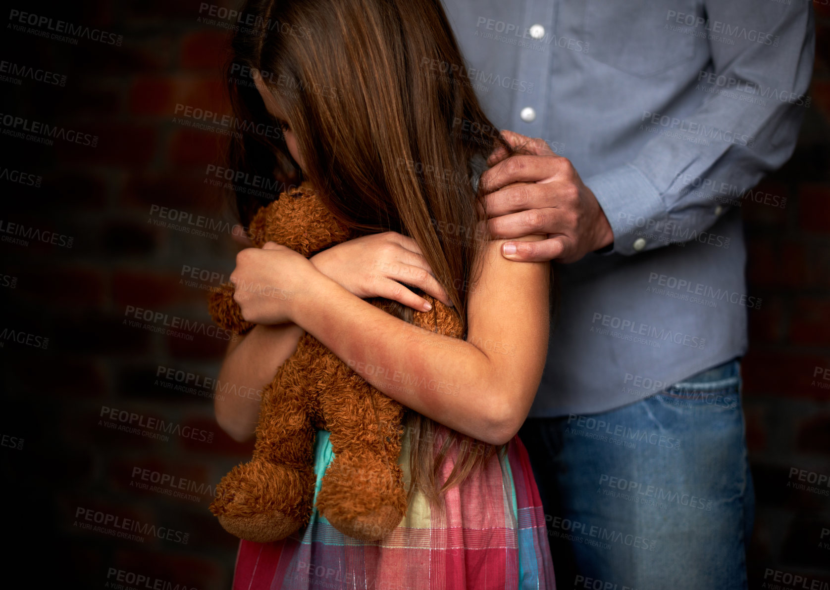 Buy stock photo Abused little girl with her abuser gripping her shoulder