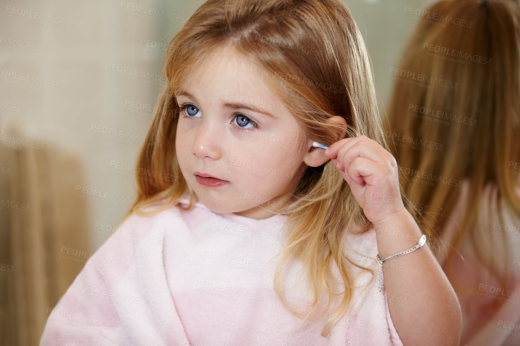 Buy stock photo Cute little girl cleaning her ears with an earbud