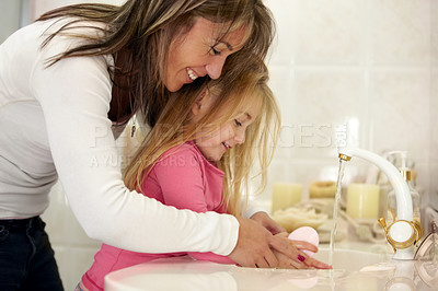 Buy stock photo Shot of a mother teaching her daughter how to wash her hands