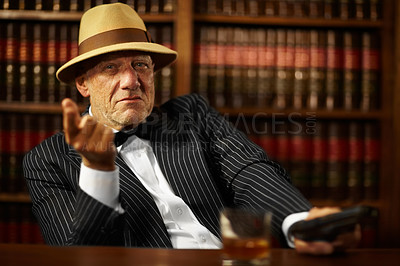 Buy stock photo Aged mob boss wearing a hat and looking serious while pointing