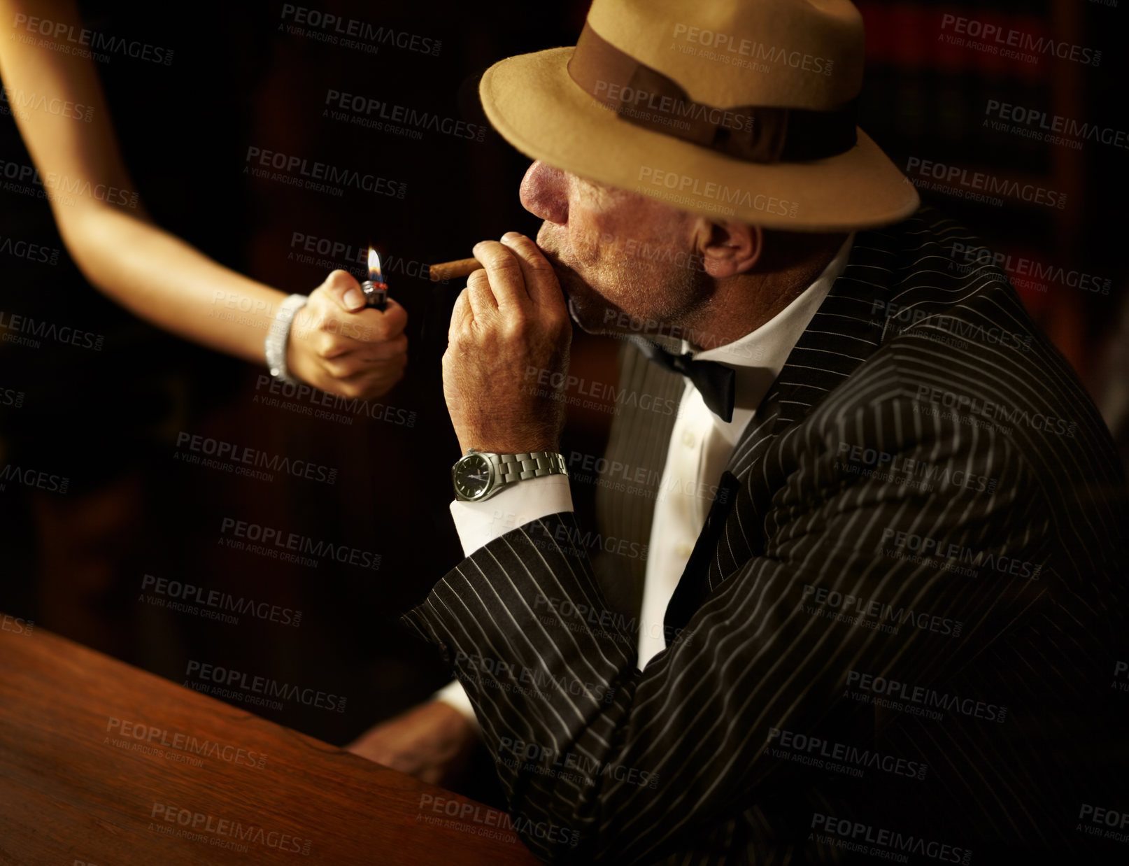 Buy stock photo Businessman, mafia and hold for cigarette in office with woman for light. Gangster, mob or person in suit, bowtie and hat for meeting, criminal activity or job with tobacco for relaxation in space