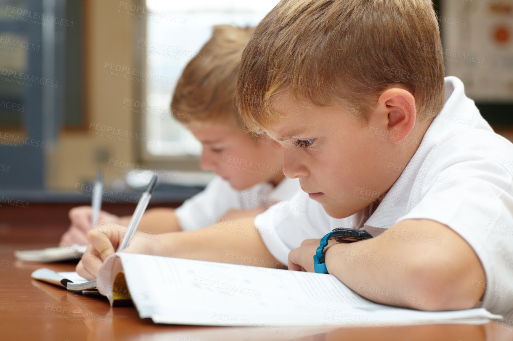 Buy stock photo Young students, classroom and writing in books for education, thinking mindset or children on scholarship. Boys, school kids or learning with creative idea on desk, studying and test or work in class
