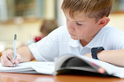 Buy stock photo Two young schoolboys doing their schoolwork in the classroom