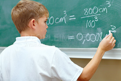 Buy stock photo Young schoolboy doing an equation on the blackboard at school