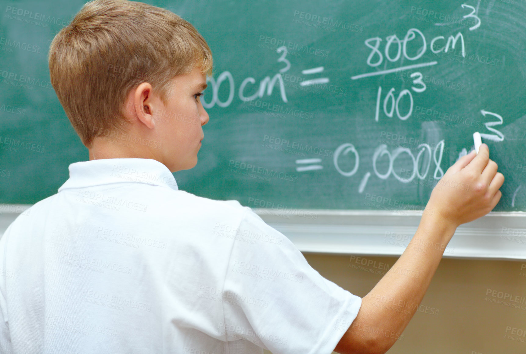 Buy stock photo Young schoolboy doing an equation on the blackboard at school