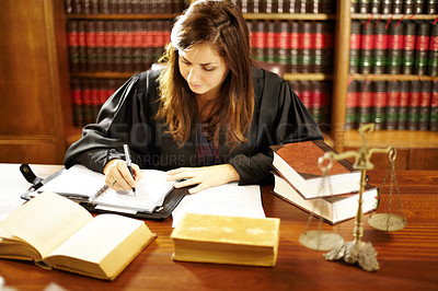 Buy stock photo Shot of a young legal professional sitting at her desk in a study